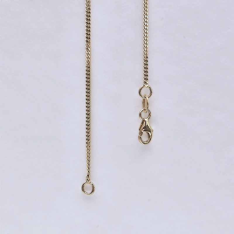 A close-up of a gold-toned chain necklace showing the extender section with a lobster clasp and adjustment ring on a plain light background.