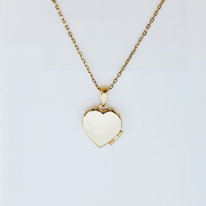 Gold heart-shaped locket necklace on a light gray background