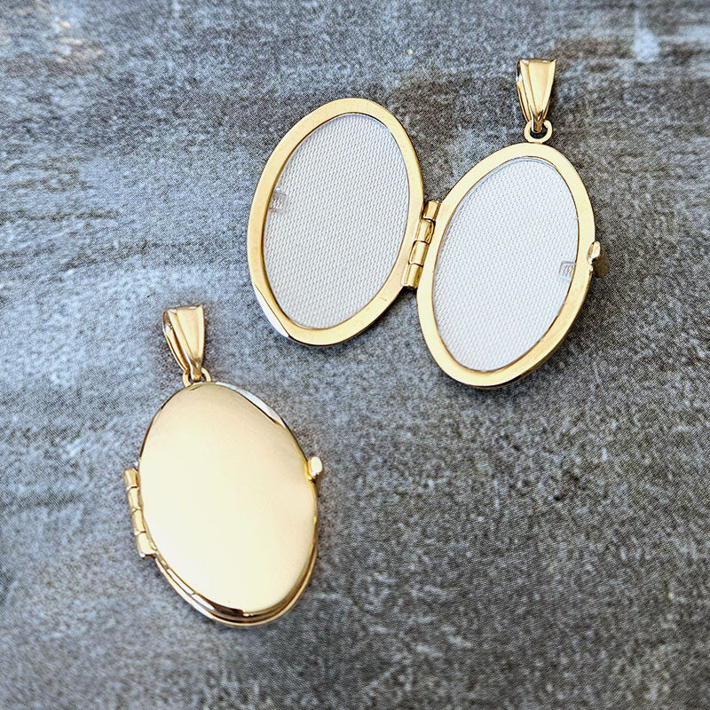 Gold locket and pendant on a textured gray surface