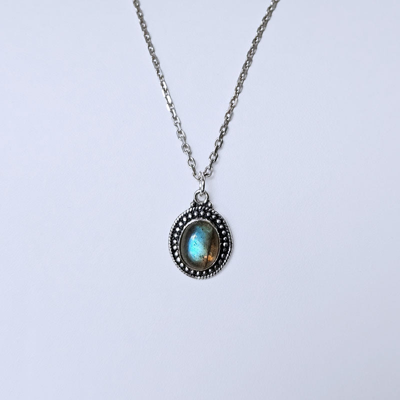 Necklace with a pendant featuring a blue gemstone on a light gray background