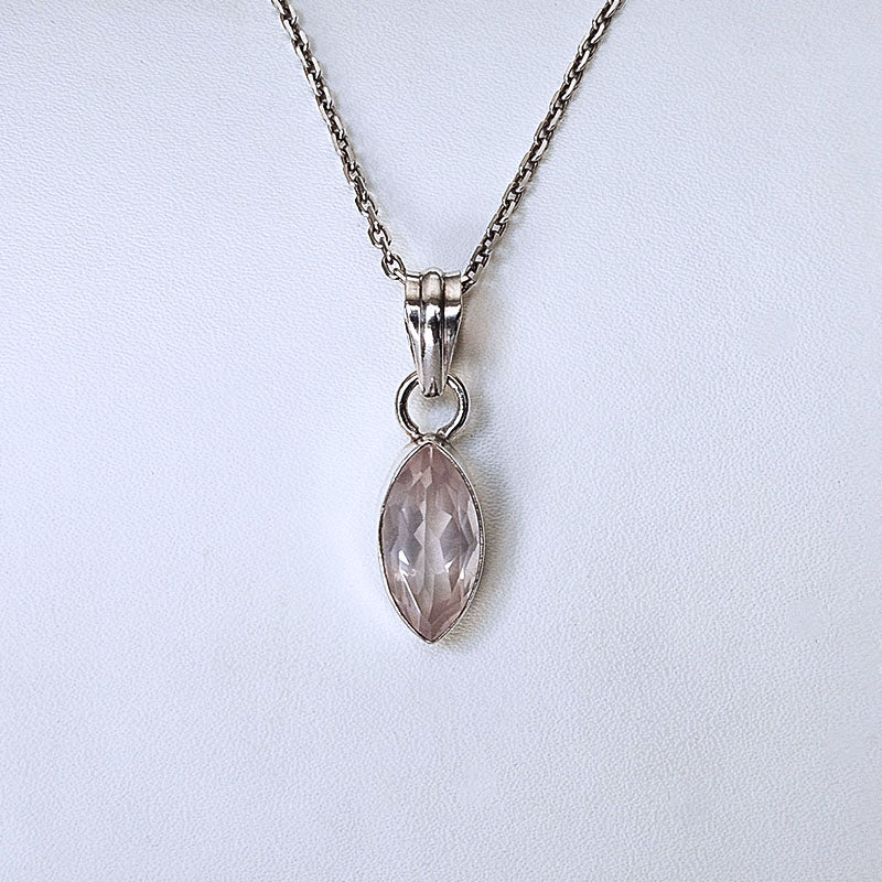 A silver chain necklace with a marquise-cut pale pink gemstone pendant in a silver bezel setting, displayed against a light gray background.