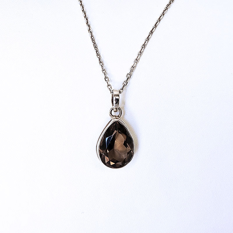 Teardrop-shaped smoky quartz pendant on a silver chain against a white background