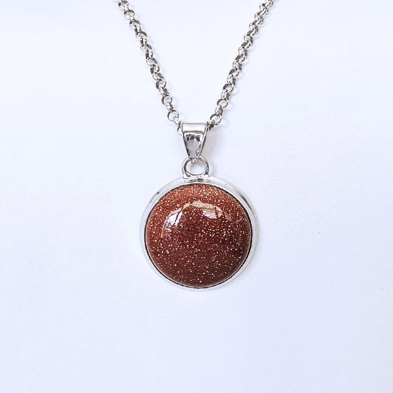 Sterling silver pendant with a sunstone stone on a silver chain against a white backdrop
