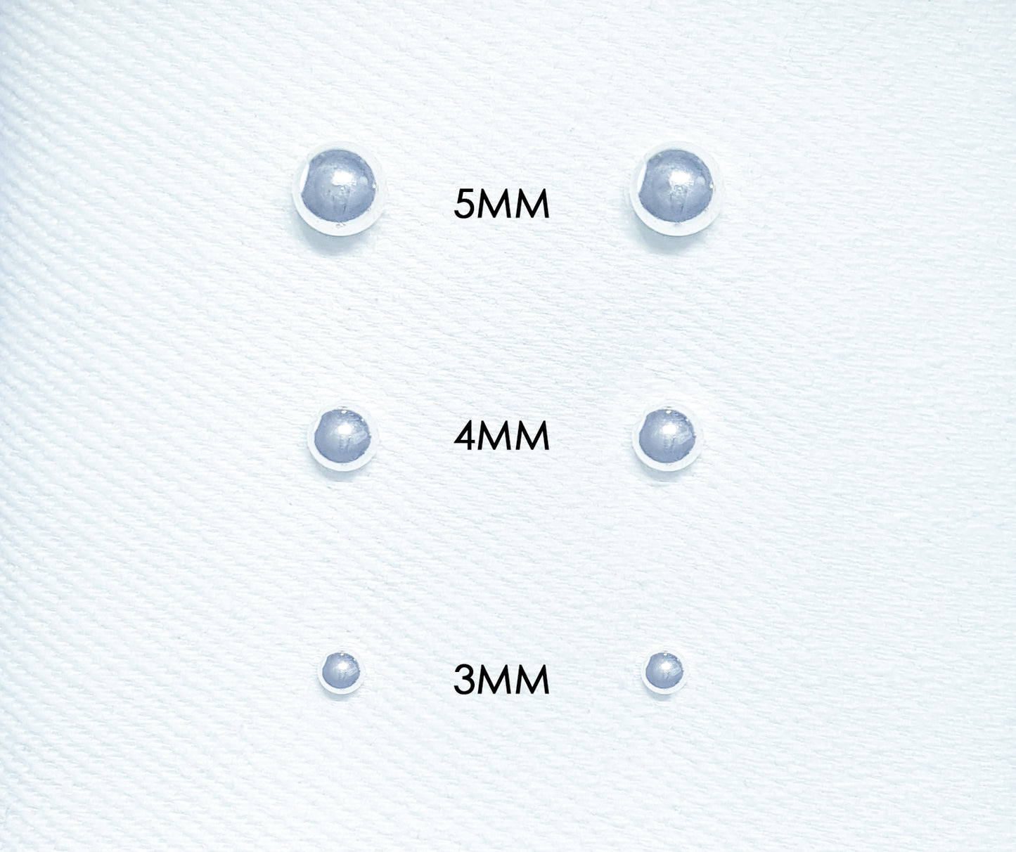 The studs feature small spherical balls made of polished metal or other materials.