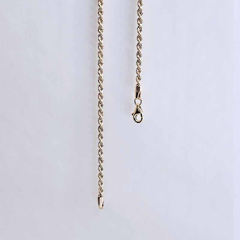 A close-up of a gold chain necklace with a lobster clasp and sliding bead end, shown against a plain light gray background.