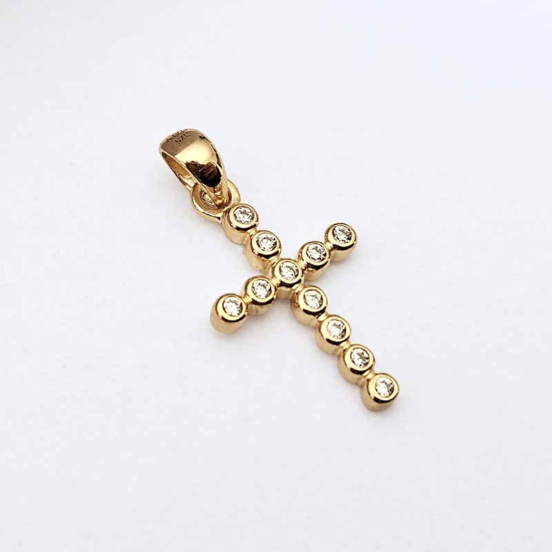 A gold cross pendant adorned with small clear gemstones set along the arms and bail, photographed on a plain white background.