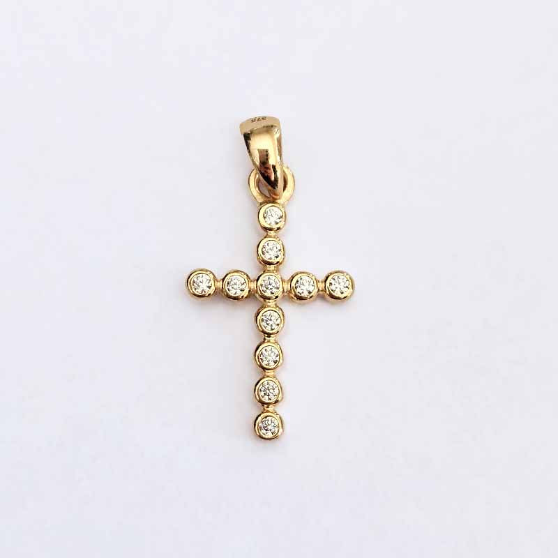 A gold cross pendant adorned with small clear round-cut gemstones, photographed against a plain white background.