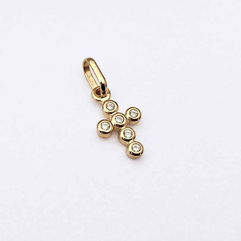 A gold cross pendant charm with six small clear gemstones, photographed on a clean white background.