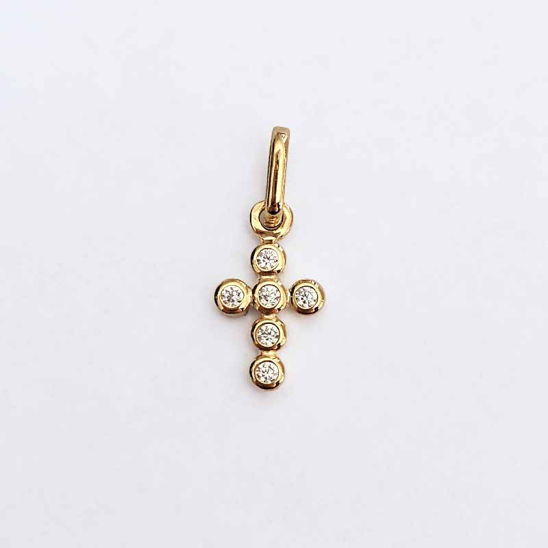 A yellow gold cross pendant featuring six small round-cut clear gemstones, set against a plain white background.