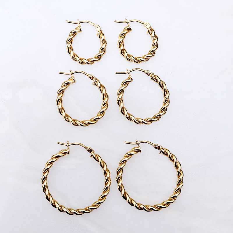 Three pairs of gold twisted hoop earrings arranged in a grid on a plain white background.