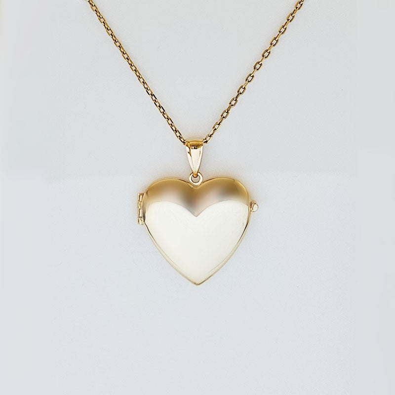 Gold heart-shaped locket on a chain against a light gray background