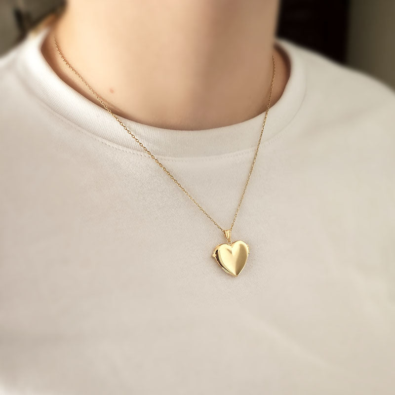 Gold heart-shaped necklace on a plain background