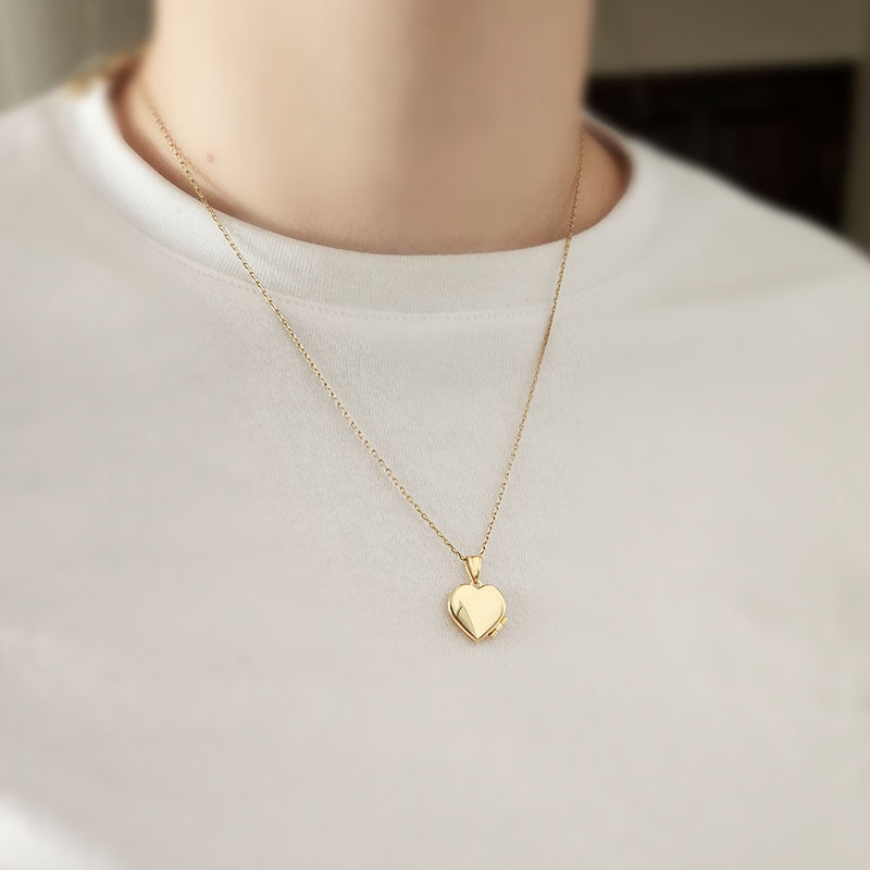 Gold heart-shaped necklace on a plain white shirt
