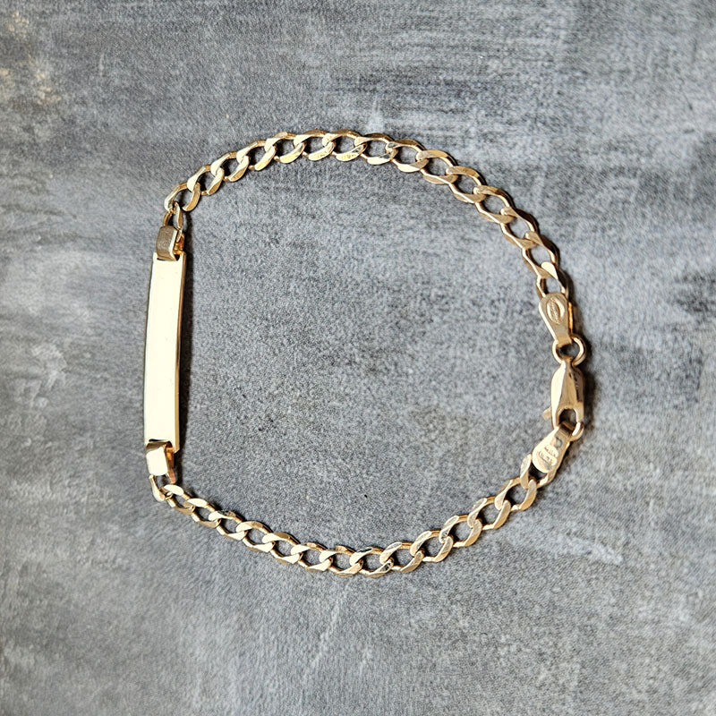 Gold chain bracelet on a gray surface