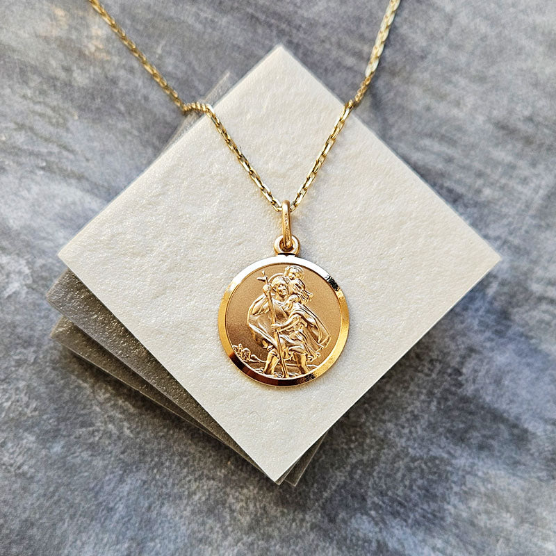 Gold necklace with a pendant on a gray surface