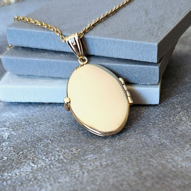 Gold necklace with a round pendant on a textured surface