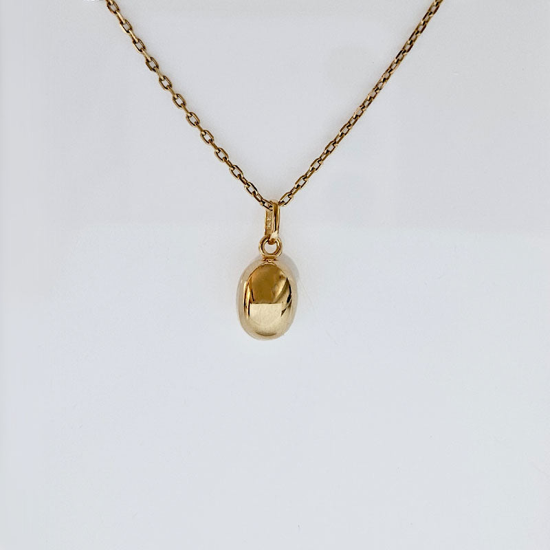 Gold necklace with an oval-shaped pendant on a white background