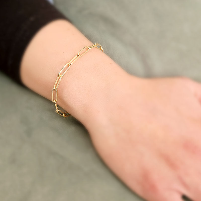 Gold bracelet on a wrist with a blurred background