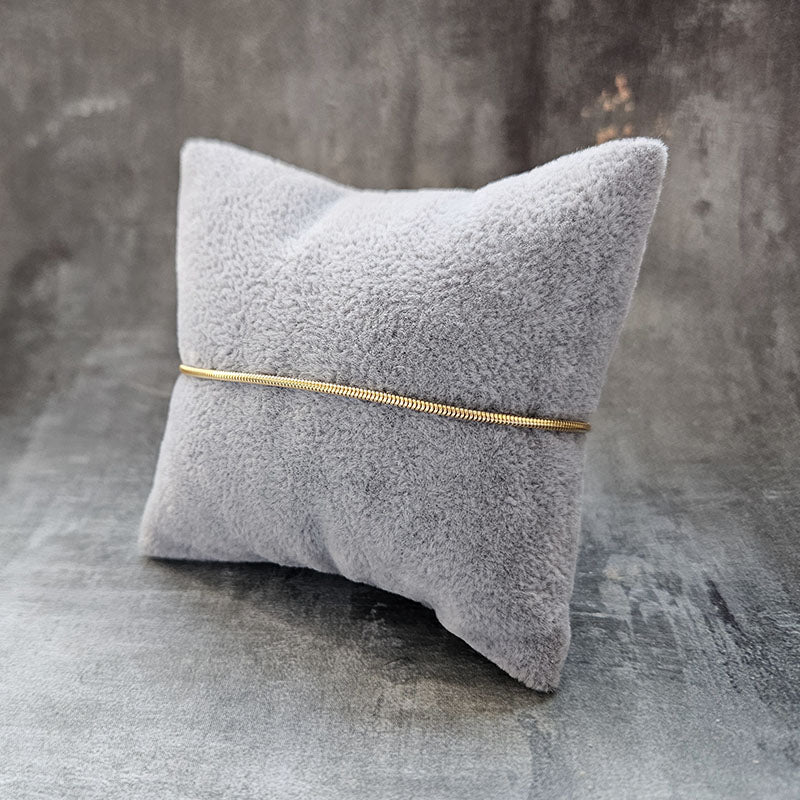 Gold Snake Bracelet on a grey cushion