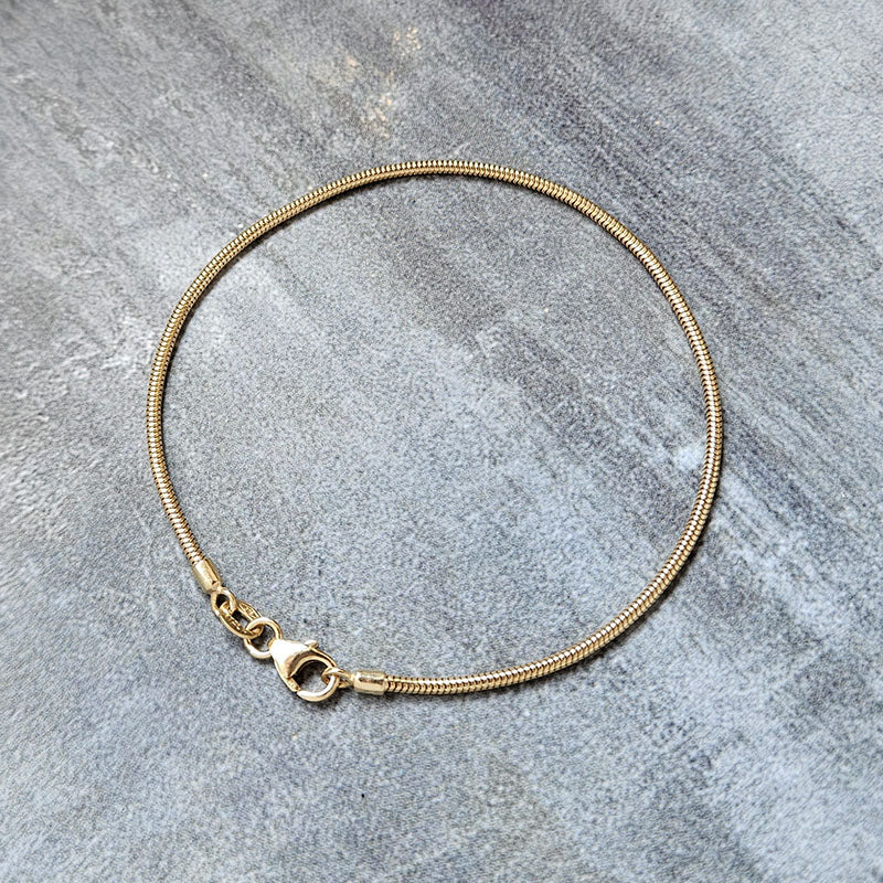 Gold Snake Bracelet on a grey background