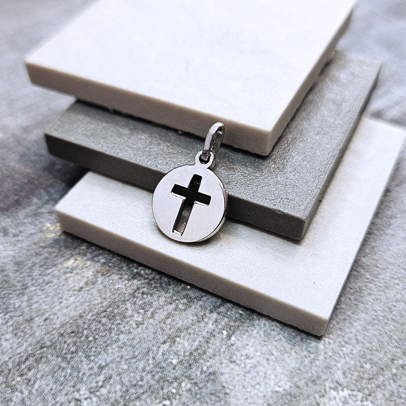 Silver pendant with a cross on a stone surface