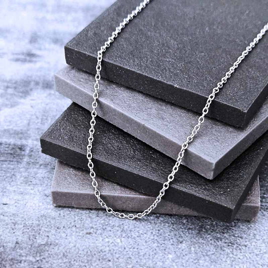 Platinum chain necklace on a stack of gray stone slabs