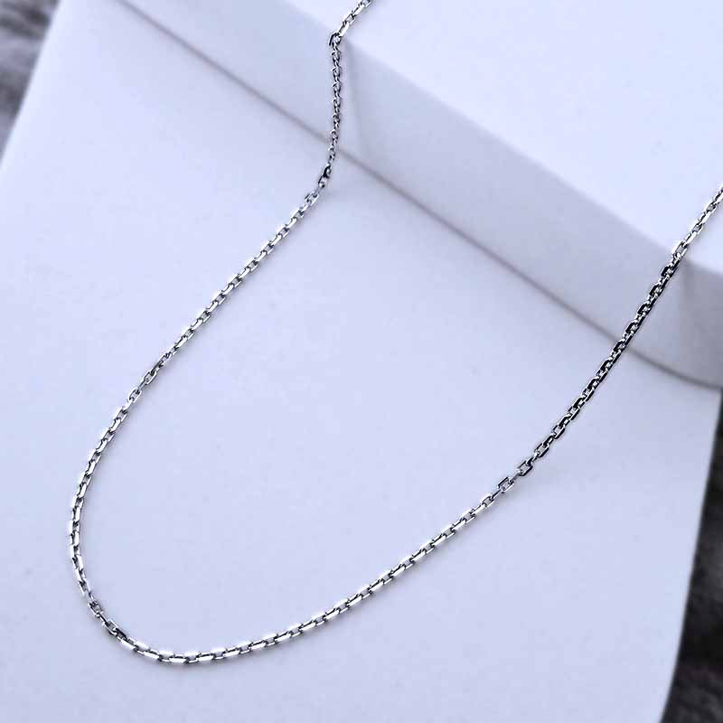 Platinum chain necklace on a white surface