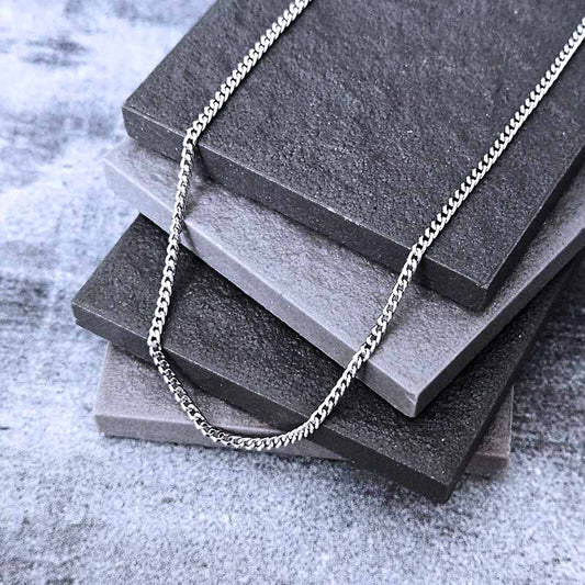 Platinum necklace on a stack of gray stone slabs