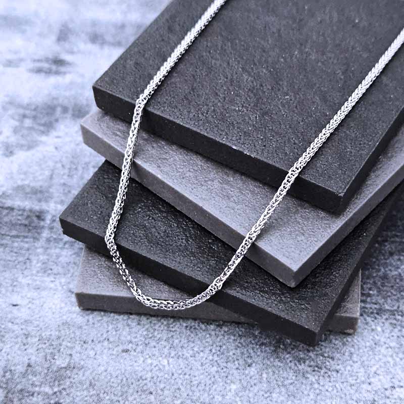 Platinum chain necklace on a stack of black stone slabs