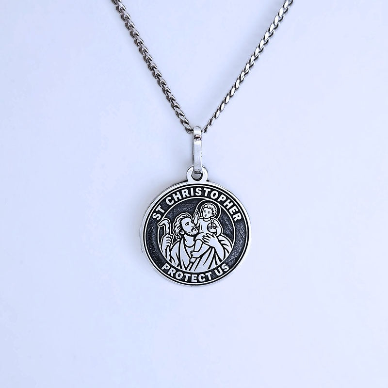 St. Christopher pendant necklace on a light purple background