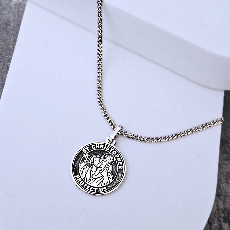 Silver St. Christopher necklace on a white surface
