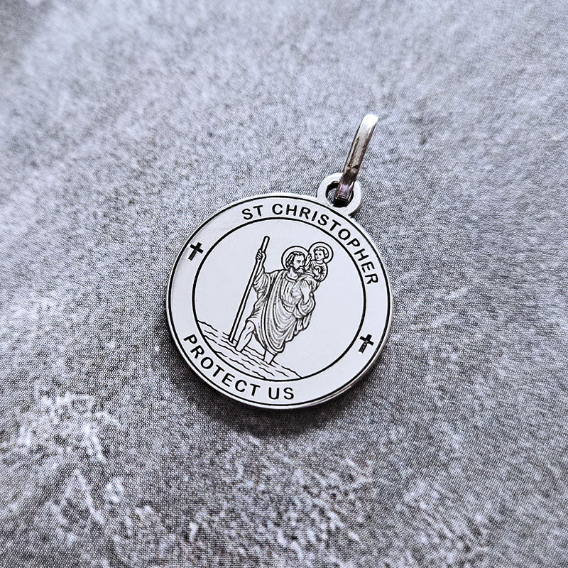 Silver St. Christopher pendant on a gray fabric background
