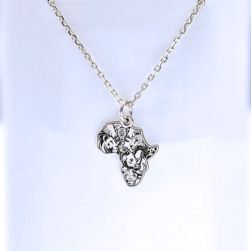 Silver necklace with a pendant shaped like Africa on a light blue background