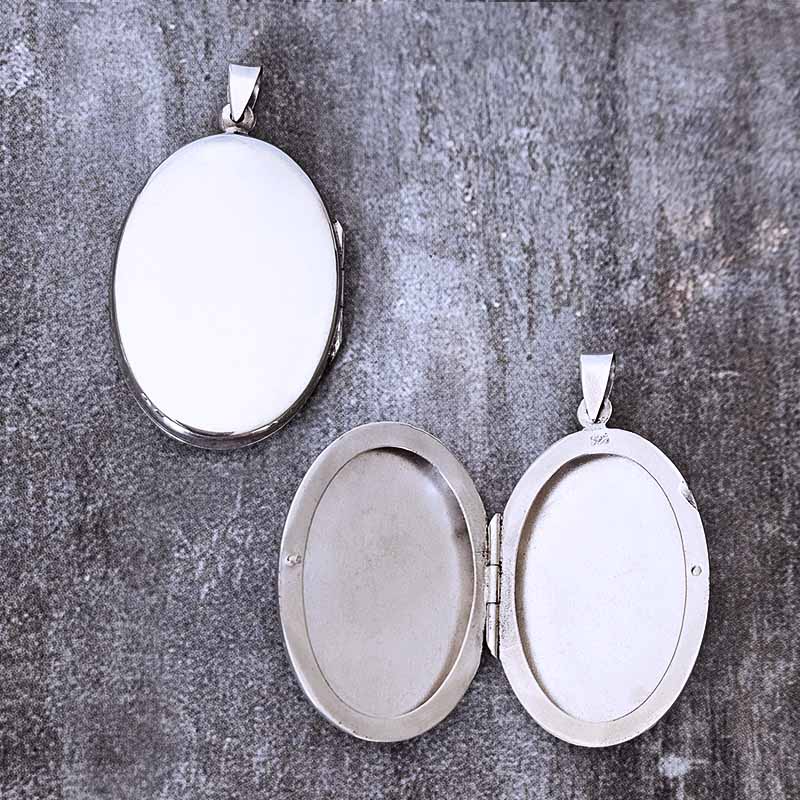 Silver oval locket on a textured gray background