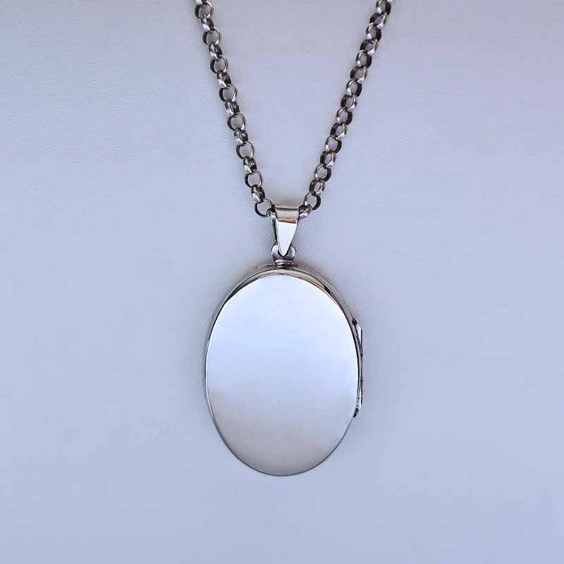Silver locket on a chain against a light gray background