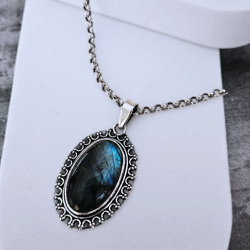 Necklace with a blue stone pendant on a white surface