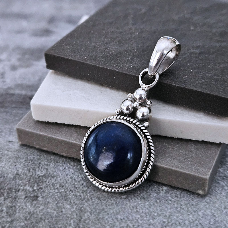 Round Lapis Lazuli Pendant on a textured surface