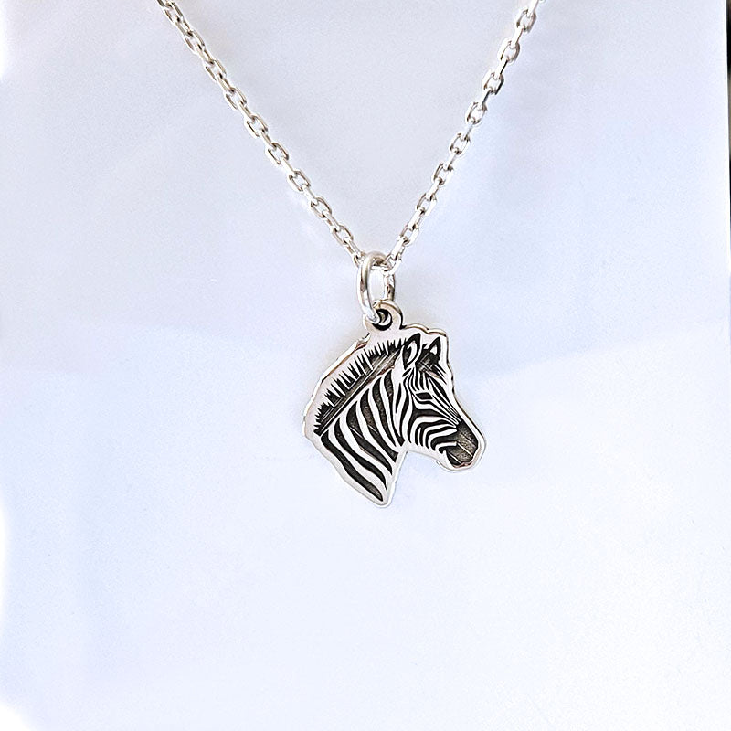 Silver zebra head necklace on a white background