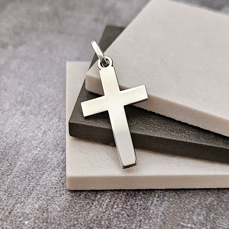 Silver cross pendant on a stone surface