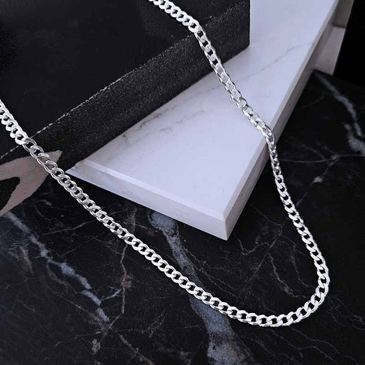 Sterling silver curb chain on a black and white marble surface
