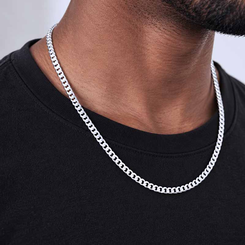 Silver chain on a man's neck, wearing a black shirt