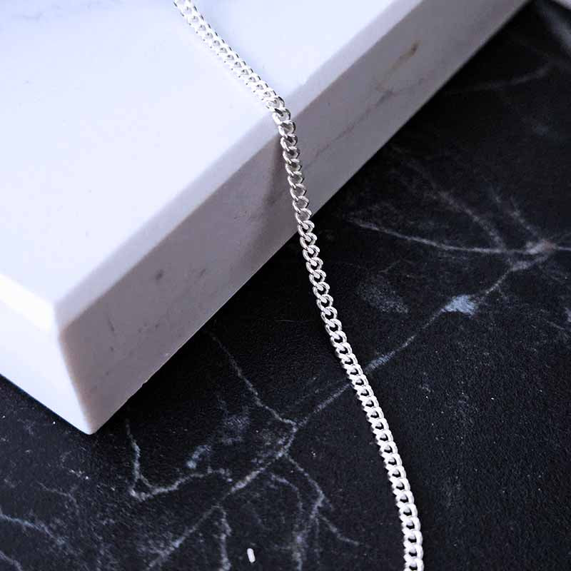 Sterling Silver Curb Chain Necklace - 1,8mm Thickness on a black and white marble surface