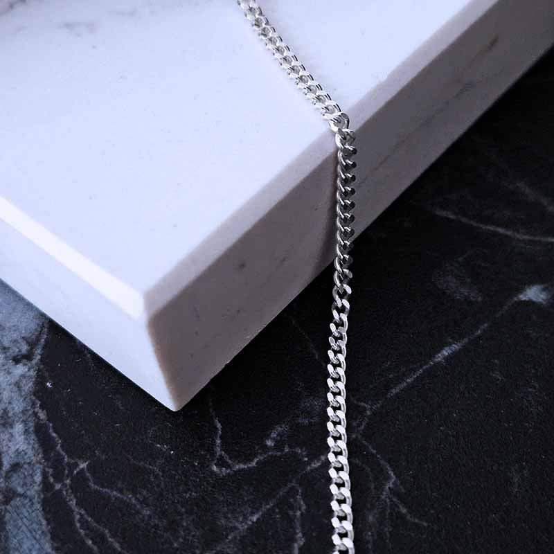 Sterling Silver Curb Chain on a white and black marble surface