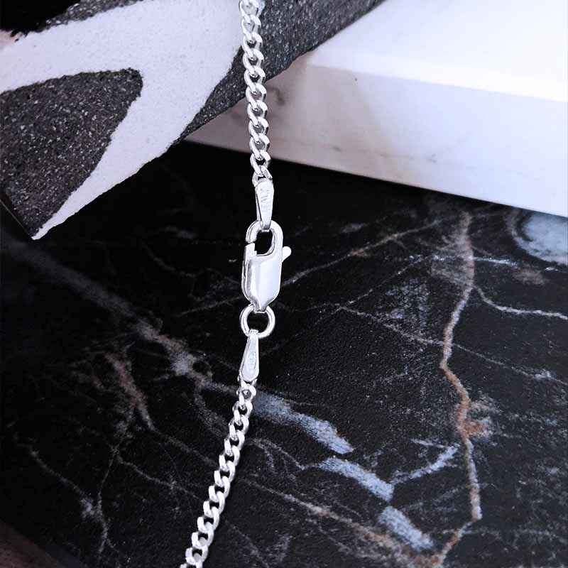 Sterling Silver Curb Chain with an Italian Clasp on a shiny black surface
