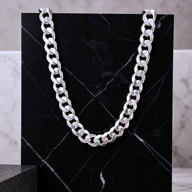 silver men's chain hanging on a dark marble background