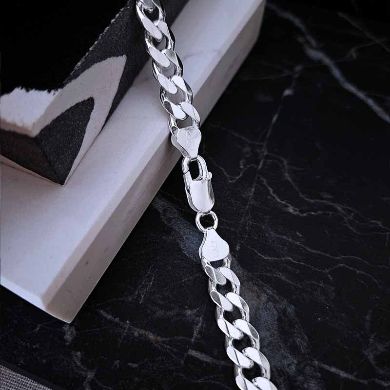 Italian clasp of a silver chain on a dark surface