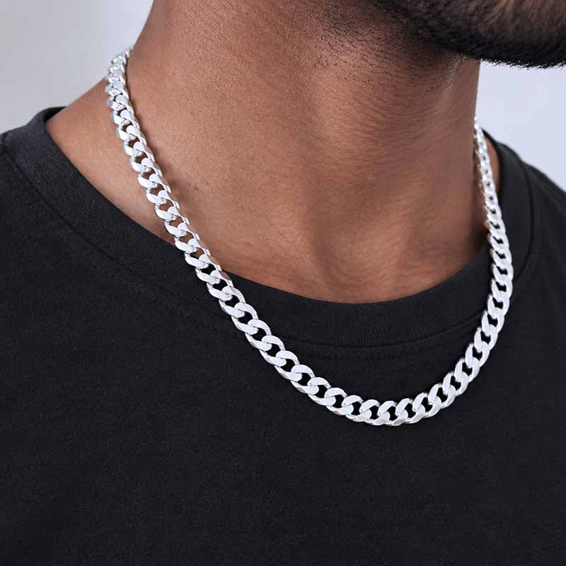 A man wearing a thick silver chain and a black shirt