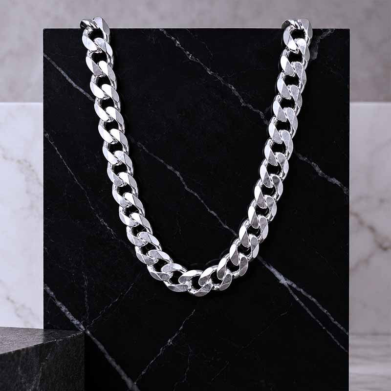 Masculine silver curb chain on a dark marble background