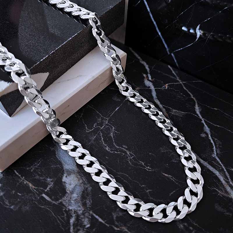 Chunky silver chain for men on a dark surface