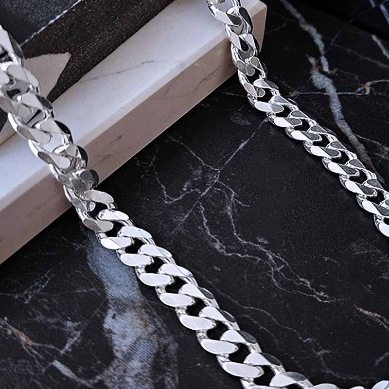 Masculine silver curb chain on a dark marble background